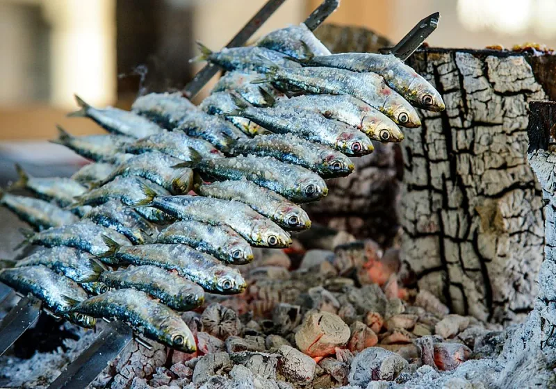 Fresh grilled whole fish and seafood dishes with white wine on a marina-side restaurant terrace in Benalmadena